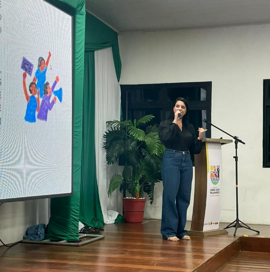 Profa. Lívia Monteiro ao púlpito durante a palestra